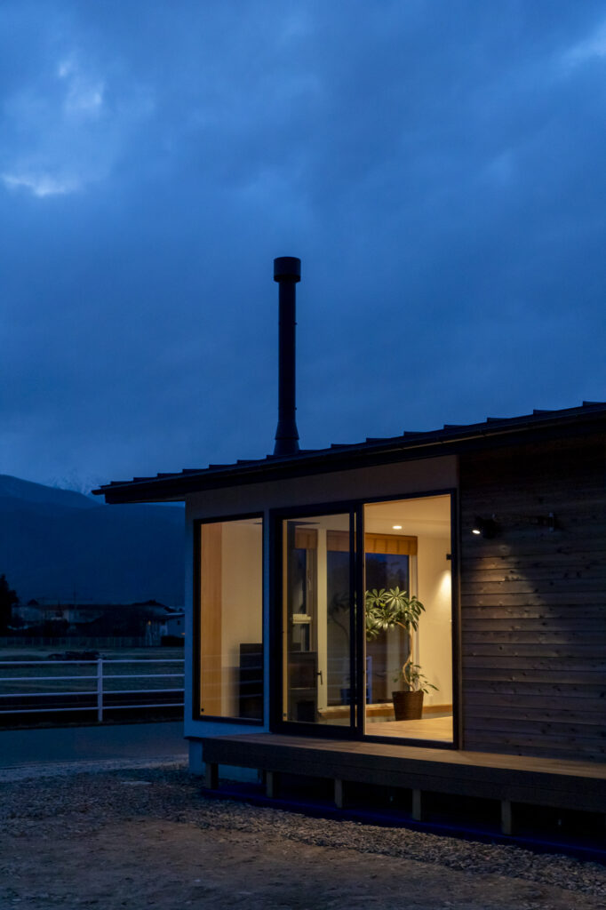 アルプスの山をゆったり眺める、薪ストーブで暖かく暮らす登山家の平屋