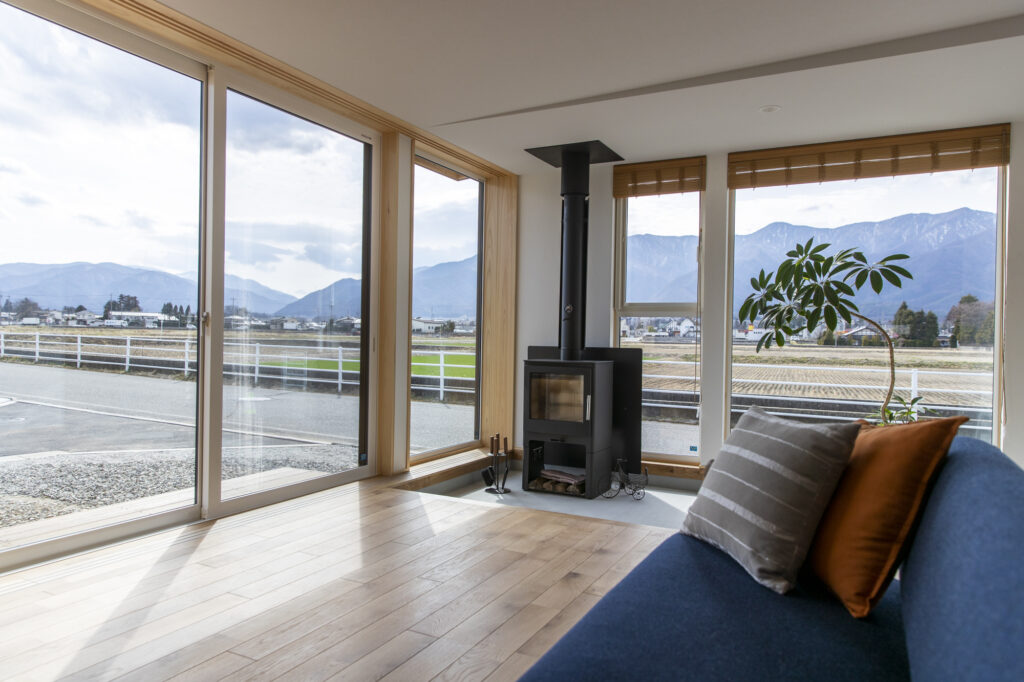 アルプスの山をゆったり眺める、薪ストーブで暖かく暮らす登山家の平屋